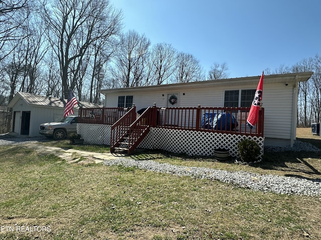 back of house featuring a yard, a deck, and an outdoor structure