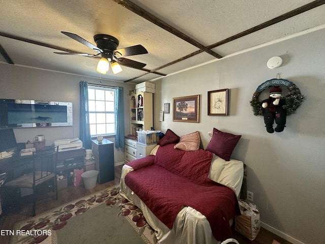 bedroom with ceiling fan, a textured ceiling, baseboards, and wood finished floors