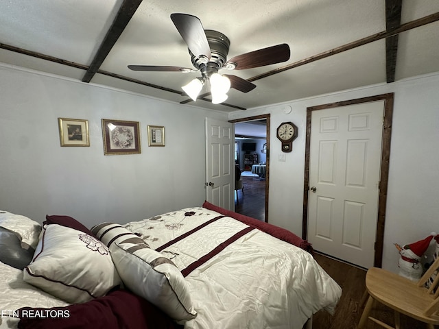 bedroom featuring beam ceiling, wood finished floors, and a ceiling fan