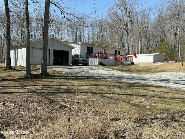 exterior space with an outdoor structure, a detached garage, and a deck