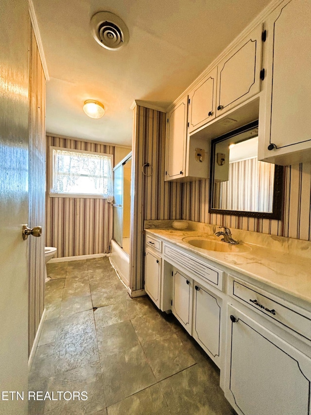 kitchen featuring light countertops, wooden walls, visible vents, and a sink