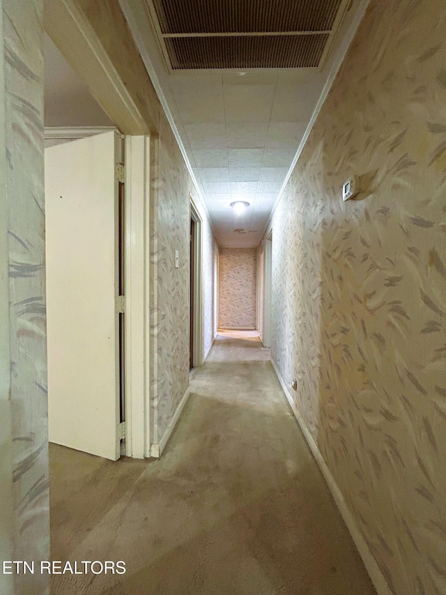 corridor featuring wallpapered walls, baseboards, visible vents, and ornamental molding