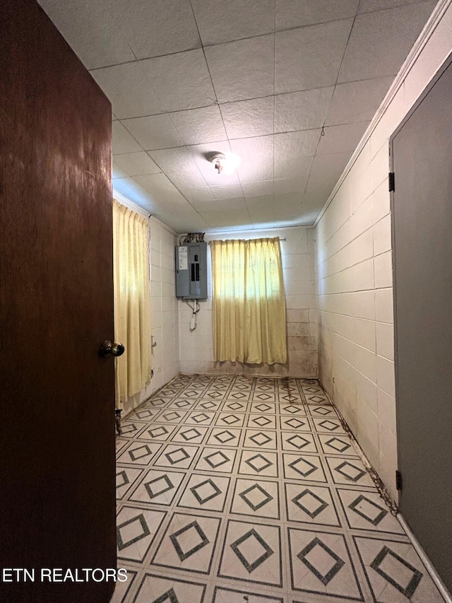 empty room with electric panel and concrete block wall