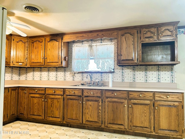 kitchen with visible vents, a ceiling fan, a sink, light countertops, and light floors