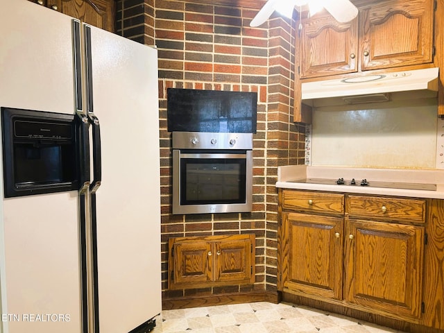 kitchen featuring brown cabinetry, white refrigerator with ice dispenser, black electric cooktop, and stainless steel oven