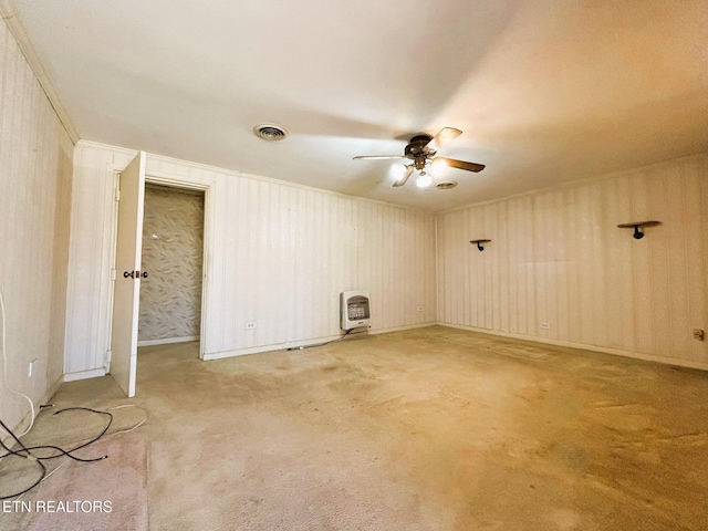 empty room featuring visible vents, ceiling fan, light colored carpet, ornamental molding, and heating unit