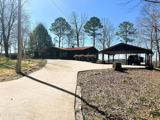 single story home featuring a chimney and concrete driveway