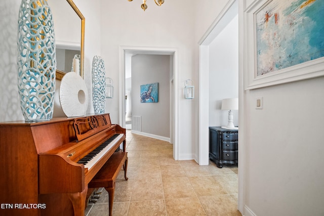 hallway featuring light tile patterned floors and baseboards