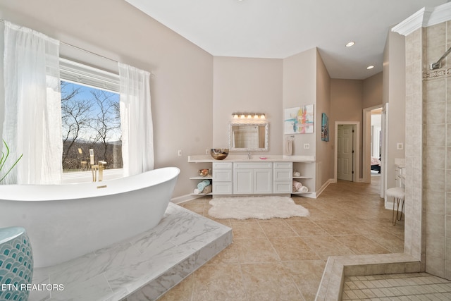 bathroom featuring tile patterned floors, recessed lighting, baseboards, a freestanding bath, and vanity