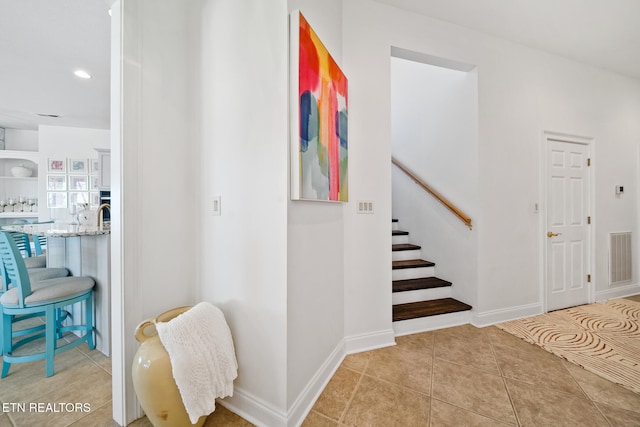 staircase featuring tile patterned floors, baseboards, and visible vents