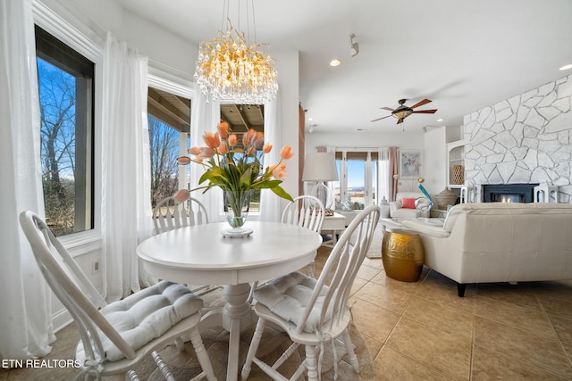 dining area with tile patterned flooring, ceiling fan with notable chandelier, recessed lighting, and a fireplace