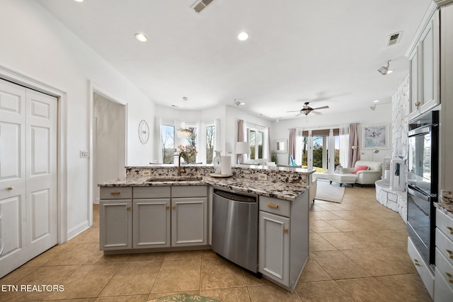 kitchen featuring open floor plan, light tile patterned floors, gray cabinets, stainless steel dishwasher, and a sink