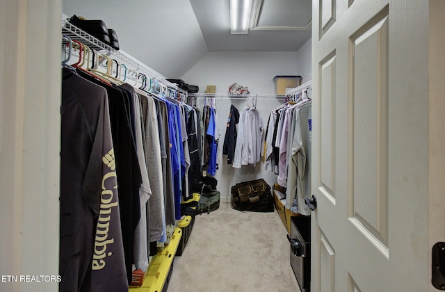 walk in closet with vaulted ceiling and carpet floors