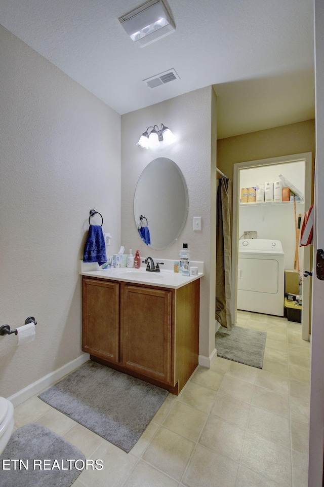 full bathroom with visible vents, baseboards, washer / dryer, and vanity