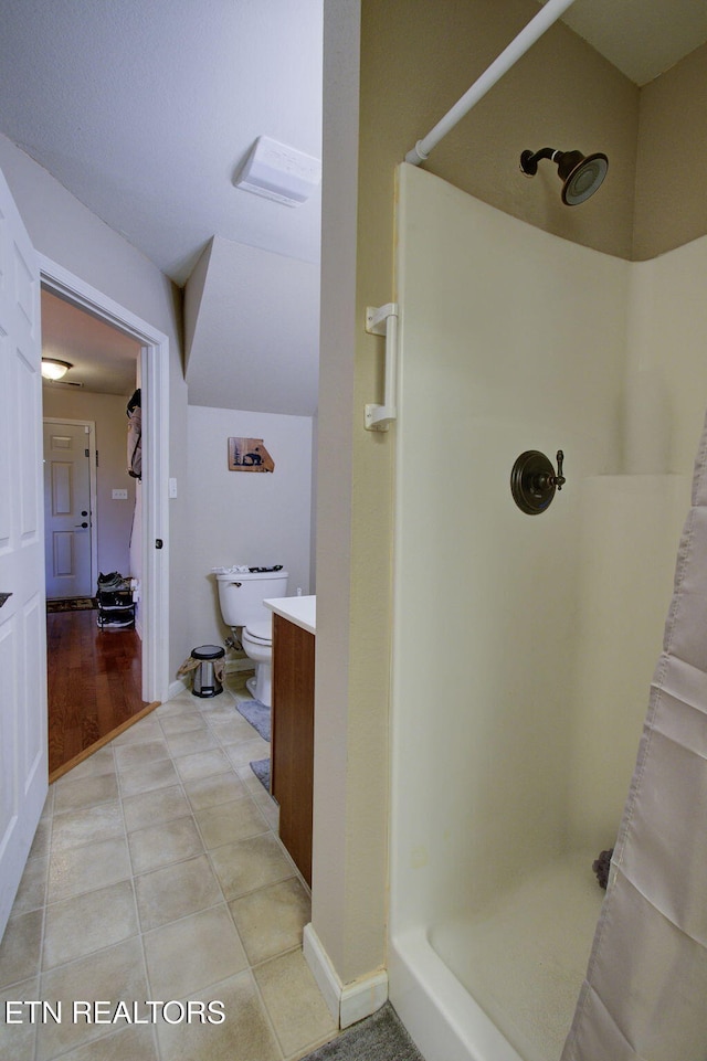 bathroom featuring vanity, baseboards, tile patterned flooring, a shower stall, and toilet