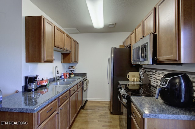 kitchen with dark countertops, visible vents, stainless steel appliances, and a sink