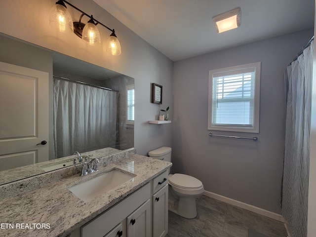 bathroom featuring vanity, a shower with shower curtain, toilet, and baseboards