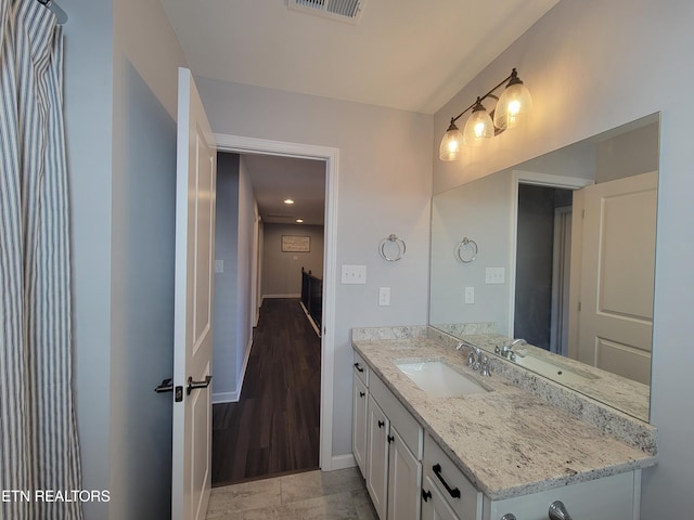 bathroom with visible vents, vanity, and baseboards