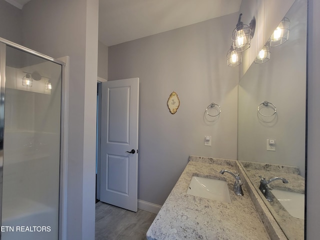 full bathroom with vanity, an enclosed shower, and baseboards