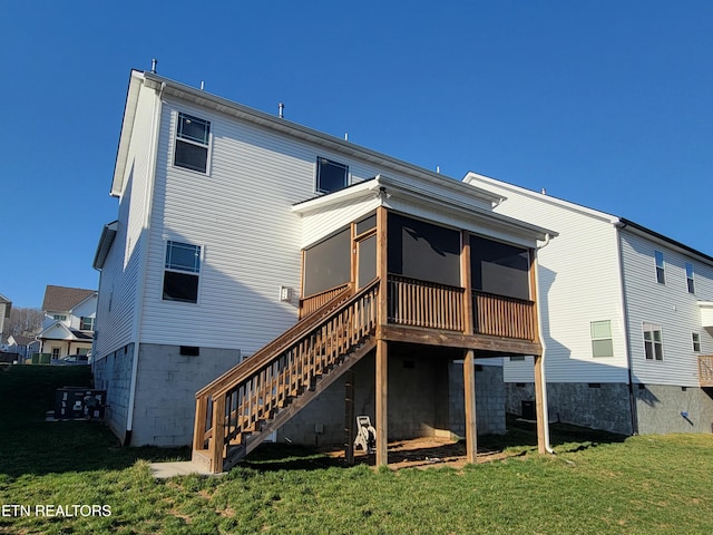 rear view of property featuring a lawn, stairs, and a sunroom