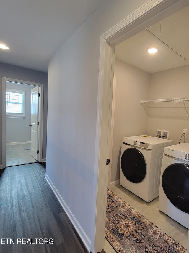 laundry area featuring baseboards, separate washer and dryer, light wood-style flooring, and laundry area