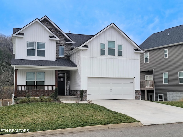 view of front of property featuring stone siding, a porch, concrete driveway, a front yard, and an attached garage