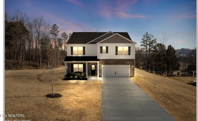 traditional-style house with a lawn, driveway, and a garage