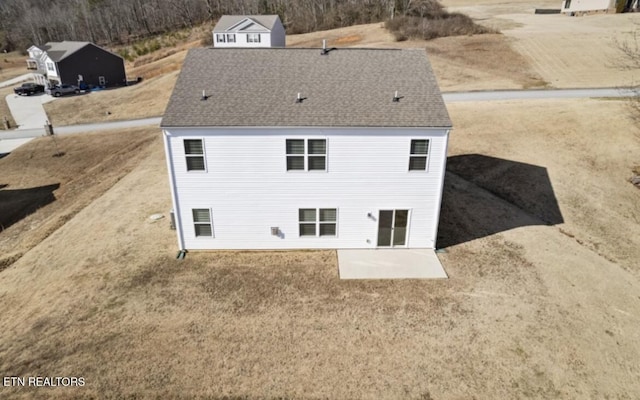 rear view of house featuring a shingled roof