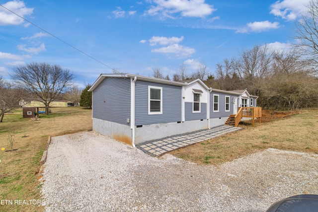 view of side of property with crawl space, a yard, and driveway