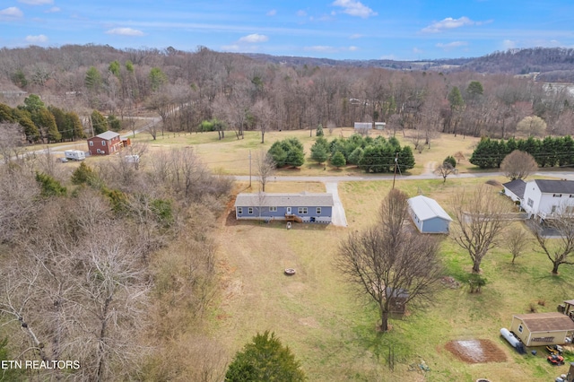 birds eye view of property featuring a rural view and a wooded view