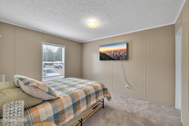 bedroom featuring a decorative wall, carpet flooring, and a textured ceiling