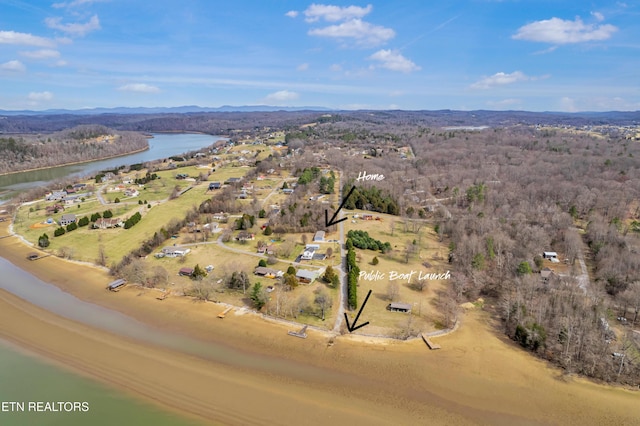 aerial view featuring a wooded view and a water view