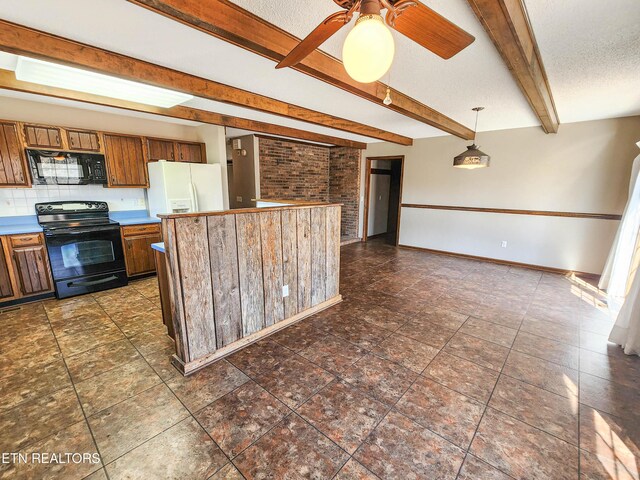 kitchen with beam ceiling, black appliances, a textured ceiling, brown cabinetry, and baseboards