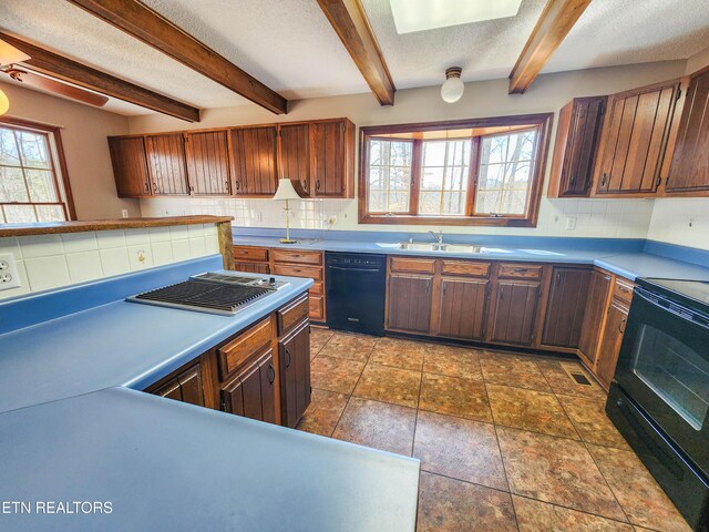 kitchen with black appliances, a sink, a textured ceiling, decorative backsplash, and a healthy amount of sunlight