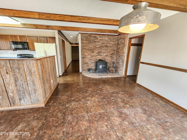 unfurnished living room featuring beamed ceiling, baseboards, and a wood stove