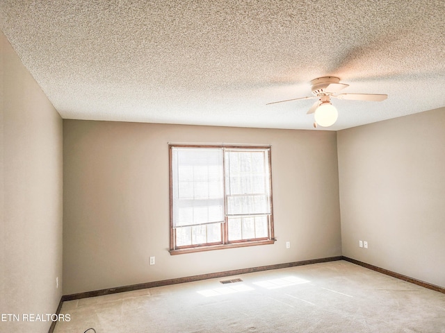 unfurnished room featuring visible vents, baseboards, light colored carpet, and a ceiling fan