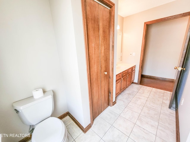 bathroom with tile patterned floors, toilet, vanity, and baseboards