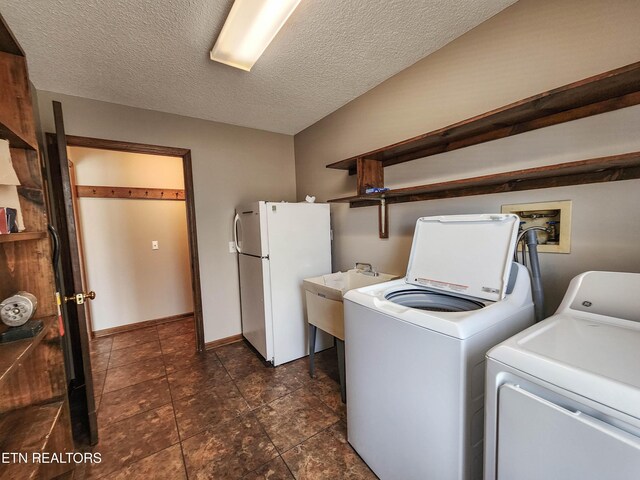 laundry room with baseboards, laundry area, separate washer and dryer, a sink, and a textured ceiling