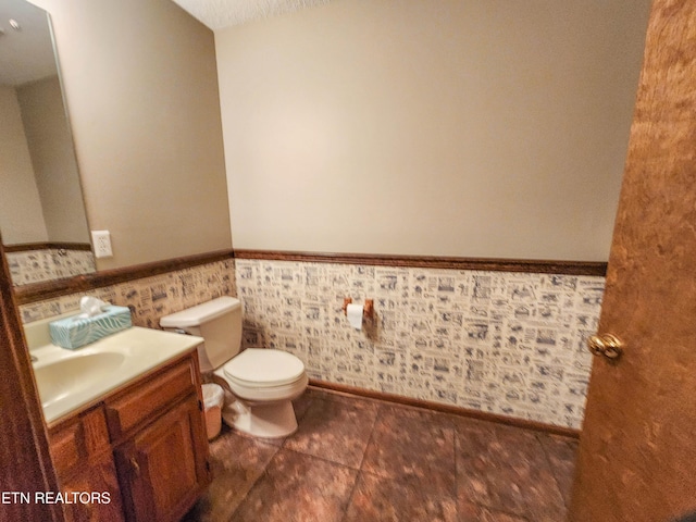 bathroom with wainscoting, toilet, and vanity