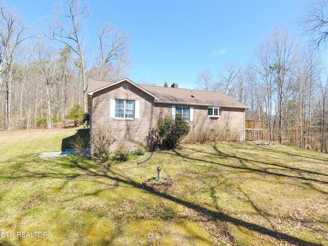 exterior space with a yard, brick siding, and a chimney