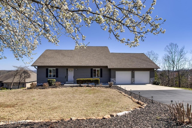 view of front of home with a front yard, an attached garage, driveway, and roof with shingles