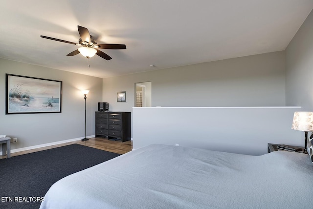 bedroom featuring baseboards, wood finished floors, and a ceiling fan