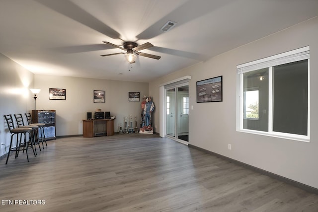 interior space featuring visible vents, baseboards, ceiling fan, and wood finished floors