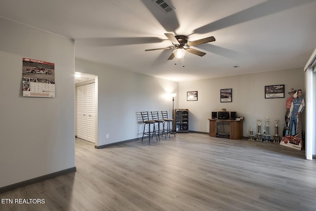 interior space featuring visible vents, baseboards, ceiling fan, and wood finished floors