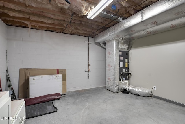 unfinished below grade area featuring concrete block wall and heating unit