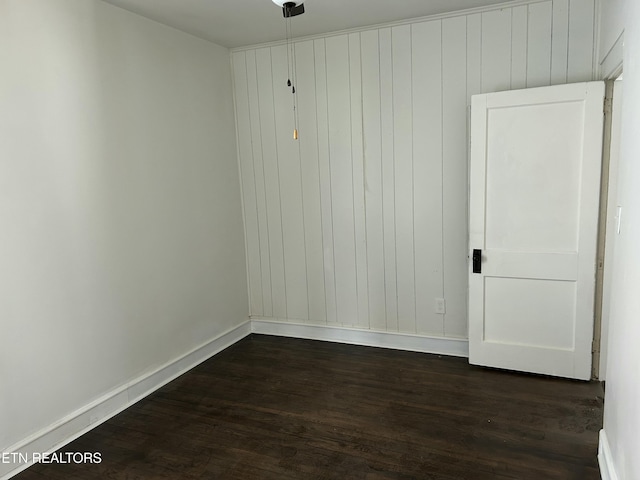 empty room with dark wood-style floors and baseboards