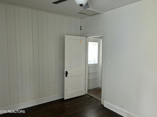 spare room with baseboards, dark wood-style flooring, and ceiling fan