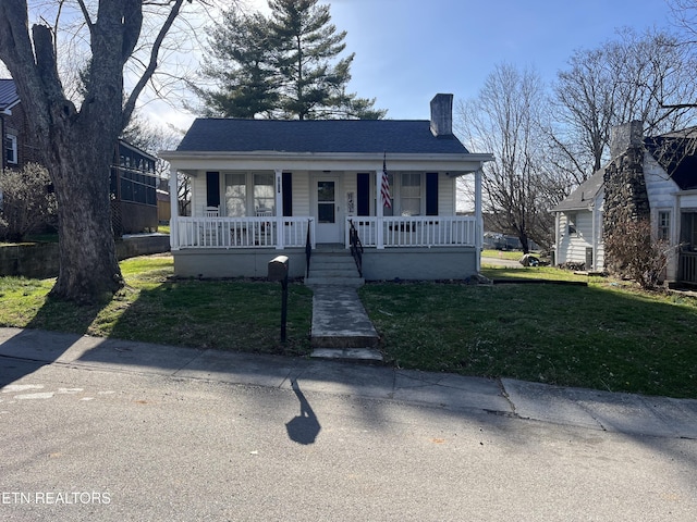 bungalow featuring a porch, a front yard, roof with shingles, and a chimney