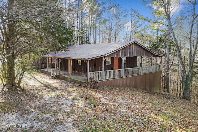 rustic home featuring a porch and metal roof