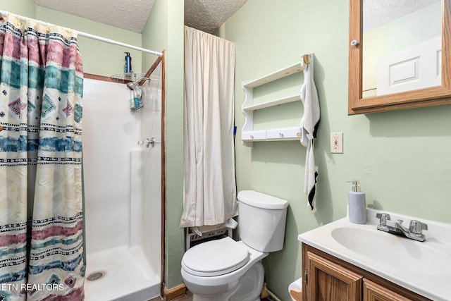 bathroom with toilet, a stall shower, a textured ceiling, and vanity